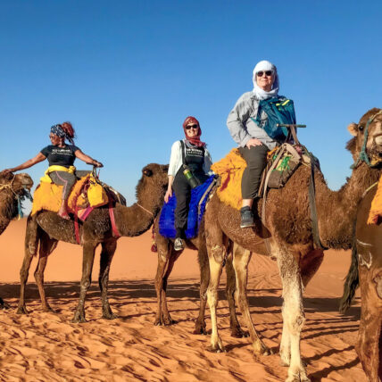 Women enjoying camel ride in Moroccon desert