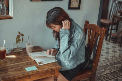 asian woman at cafe reading a book