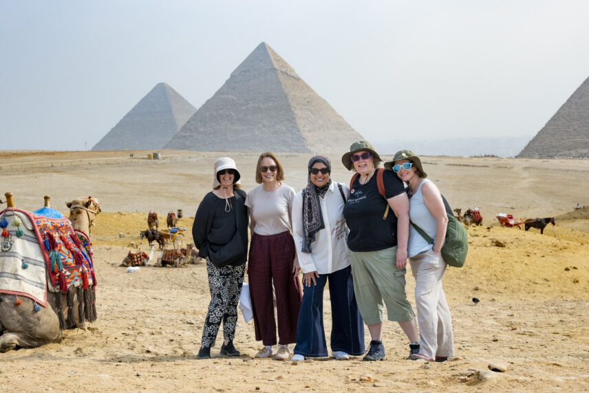Women travelers standing on a sand dune overlooking the Pyramids of Giza